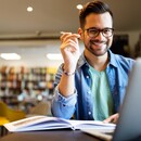smiling-male-student-working-studying-library-900.jpg